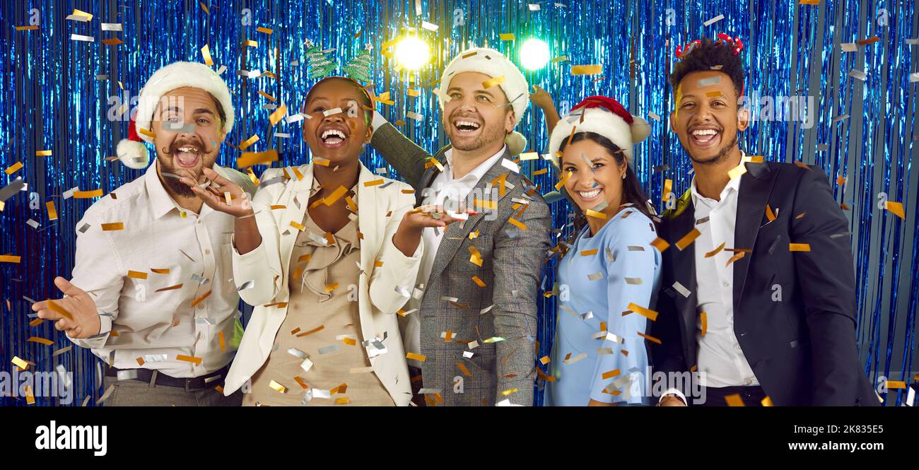 Happy joyful diverse friends having fun and dancing at New Year party with confetti Stock Photo