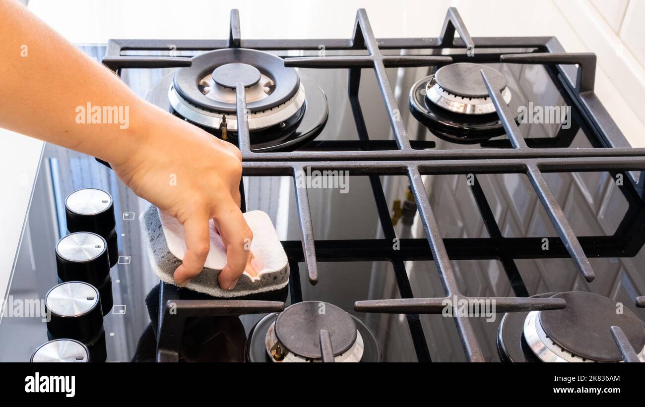 Female hand washing gas stove with sponge Stock Photo Alamy