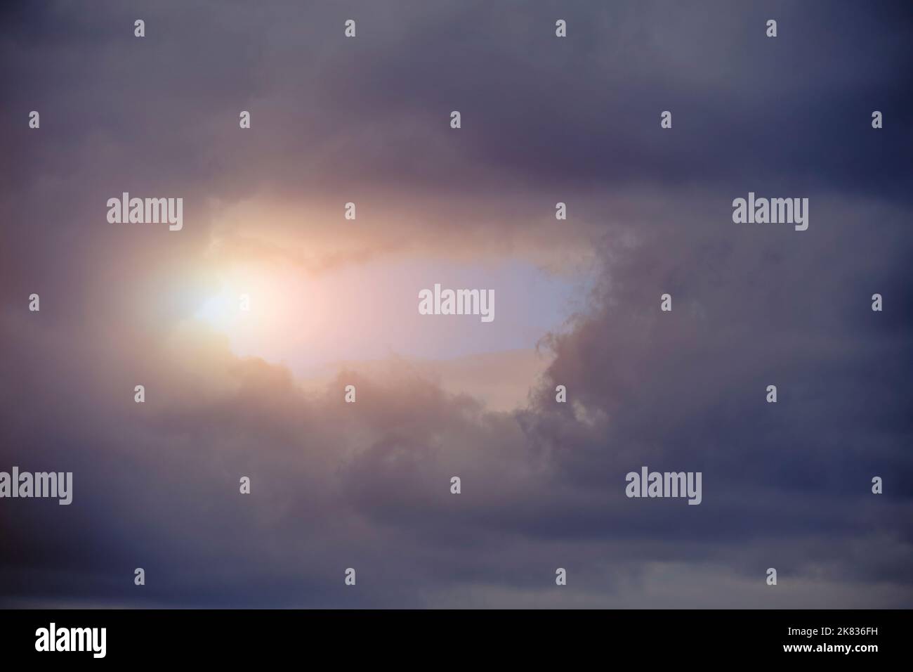 Breaking sunlight through gap of storm clouds Stock Photo