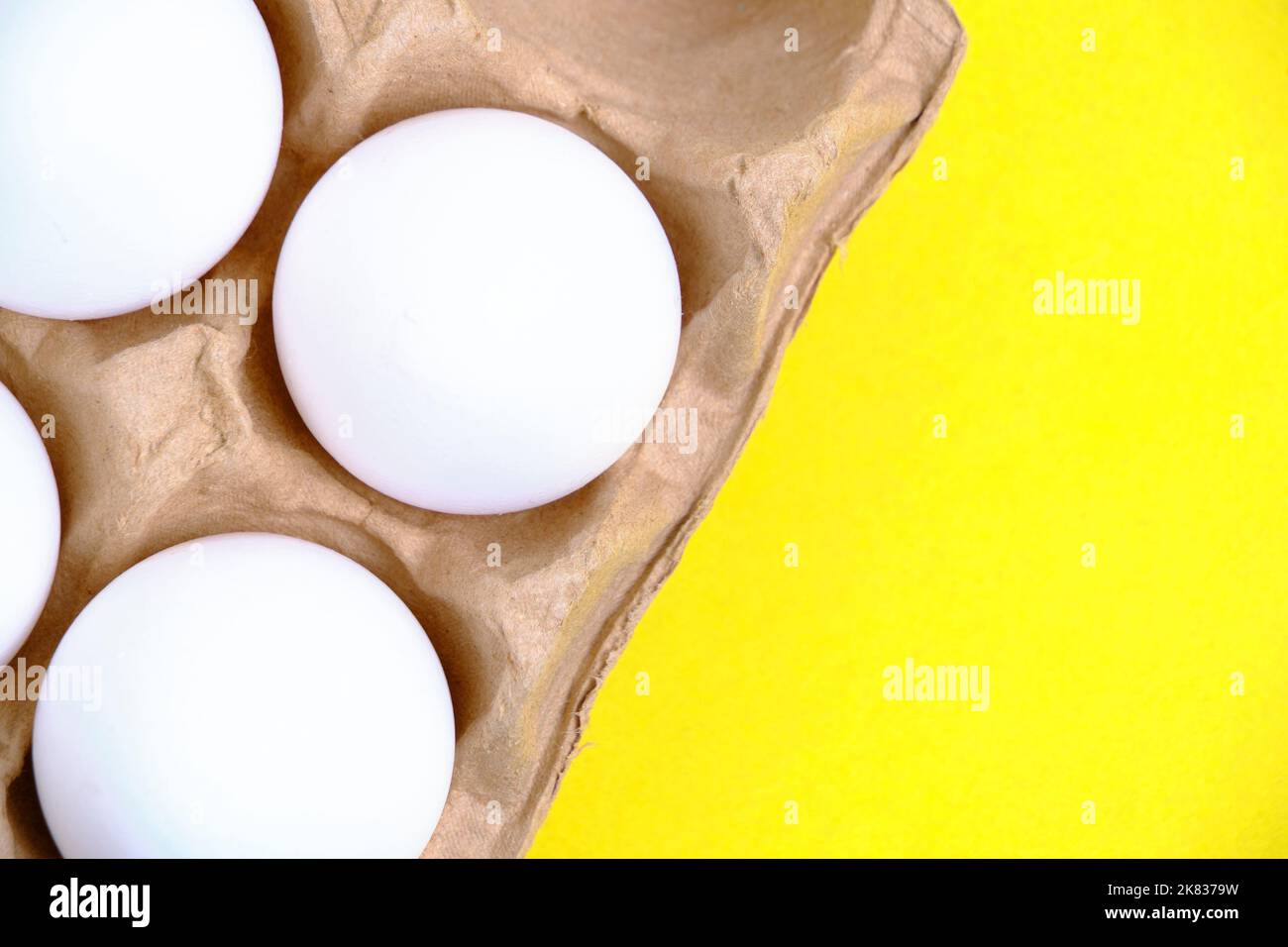 Chicken white eggs in tray on yellow background Stock Photo
