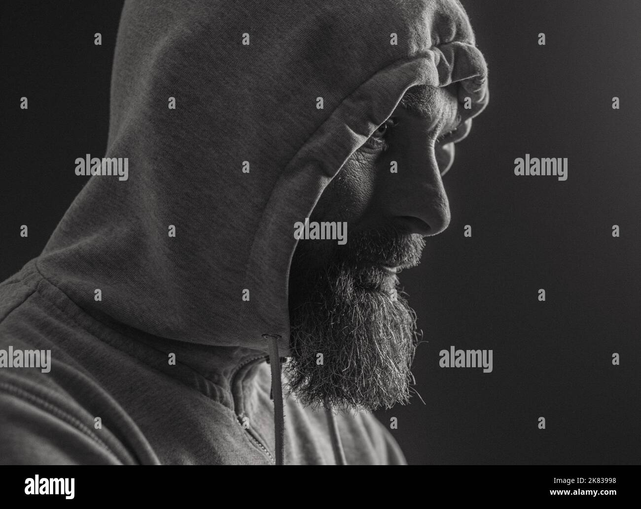 man with hood on a dark background depression or hacker Stock Photo