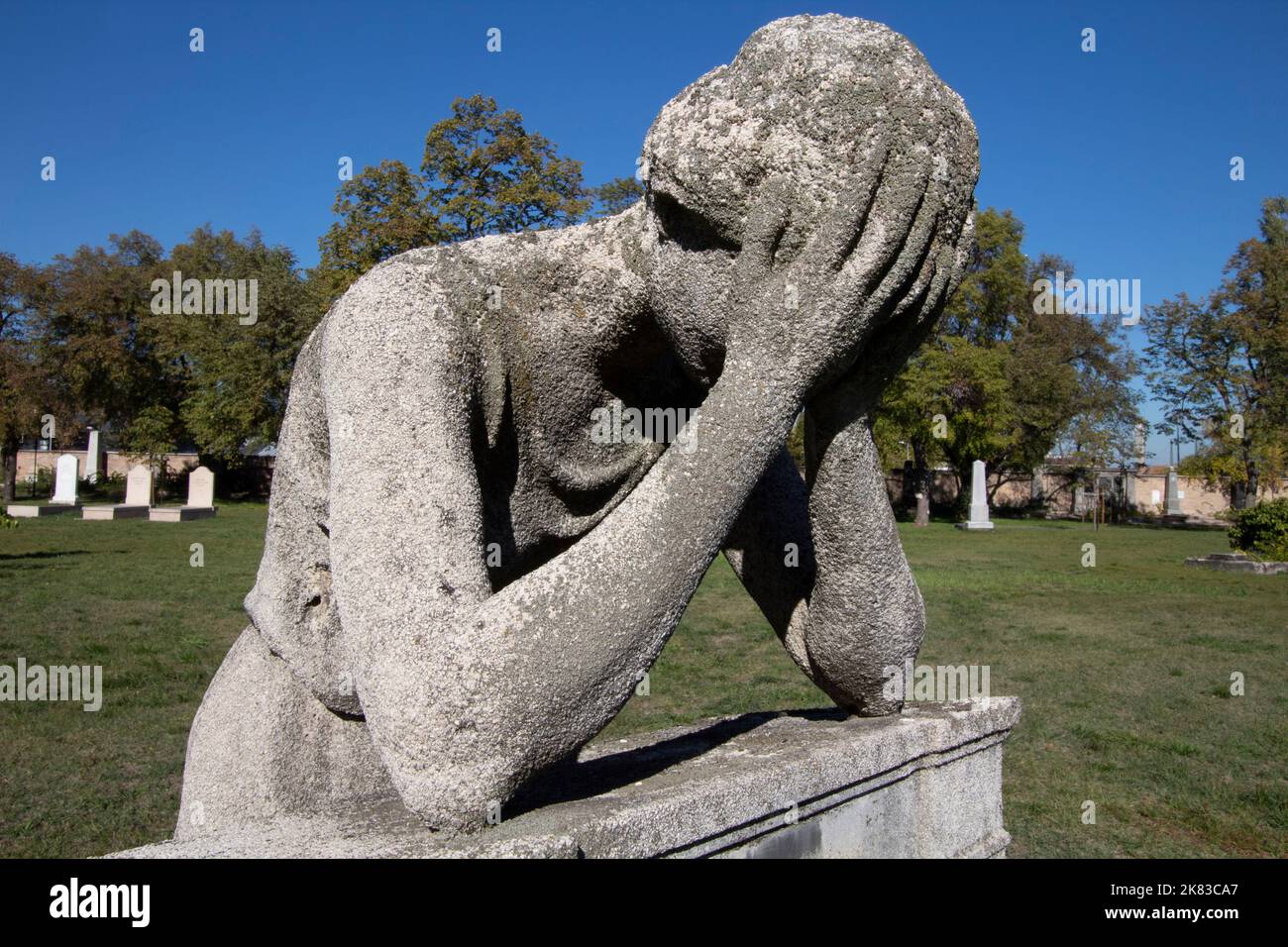 Statue of a boy with his head in his hands in Kerepesi Cemetery Budapest Hungary Stock Photo