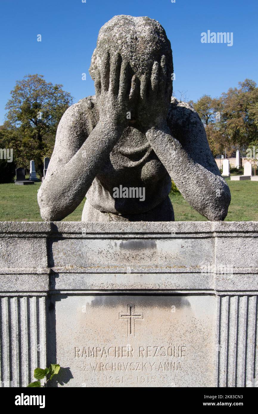 Statue of a boy with his head in his hands in Kerepesi Cemetery