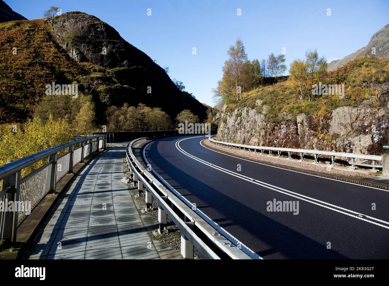 Roadway and footpath through hills in the scottish highlands Stock