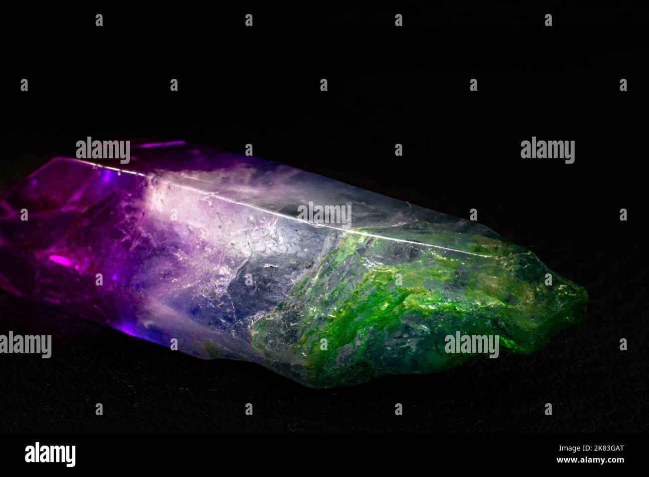 Vibrant colorful Cocktail aura quartz point macro isolated on a black surface. Colorful, pink, blue, white, purple and green man-enhanced Stock Photo