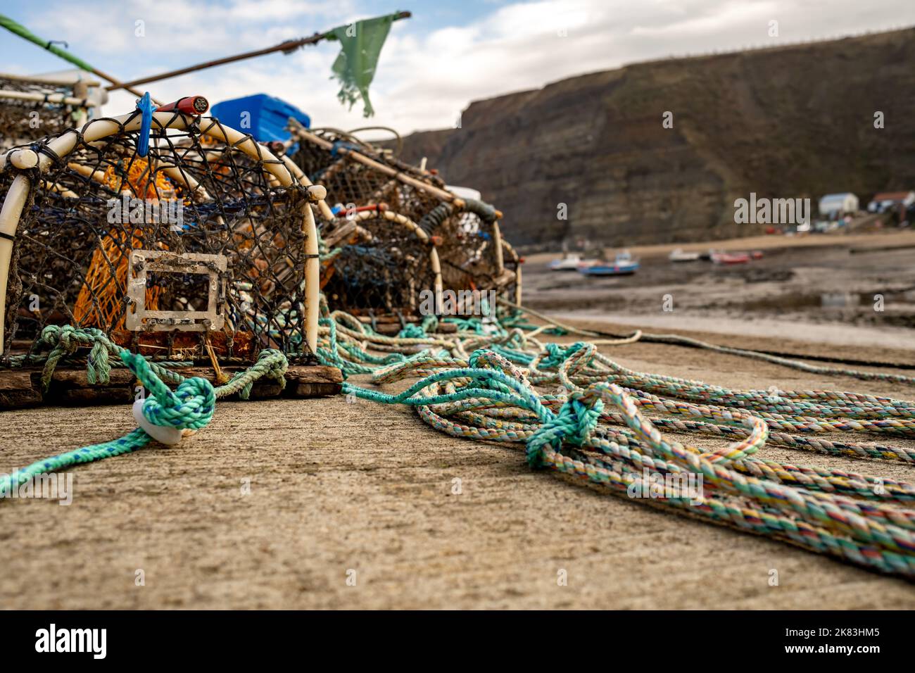 Crab pots, lobster, pots, fish traps, fish nets and other fishing gear on  the harbour wall in the historic fishing village of Stathes on the North  Yor Stock Photo - Alamy