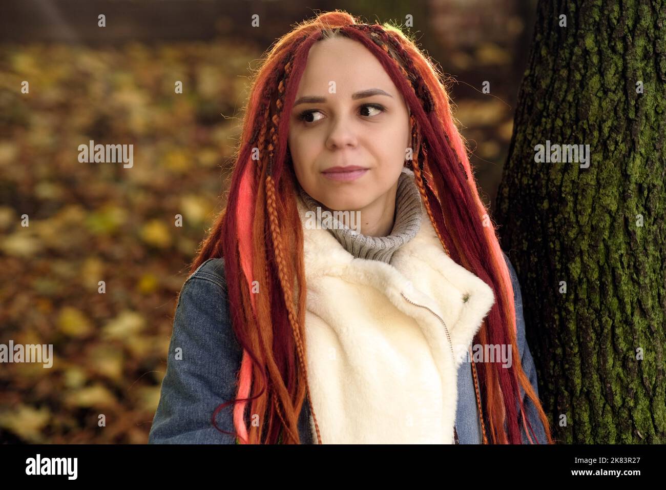 Dramatic portrait of young female with horror black stage makeup painted on  face and orange color dreadlocks hairstyle. Studio shot on blue background  Stock Photo - Alamy