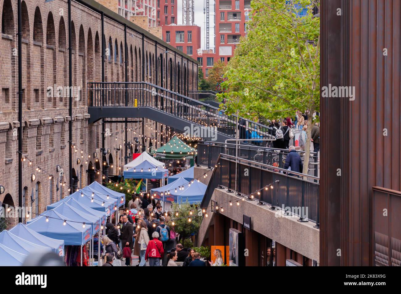 The Drops Market people walking under the lights in Coal Drops Yard