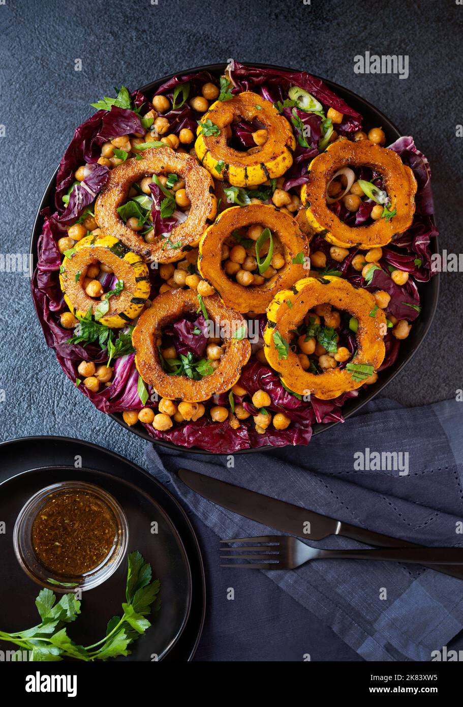 Overhead Delicata squash salad with radicchio, chickpeas with a side of dressing Stock Photo