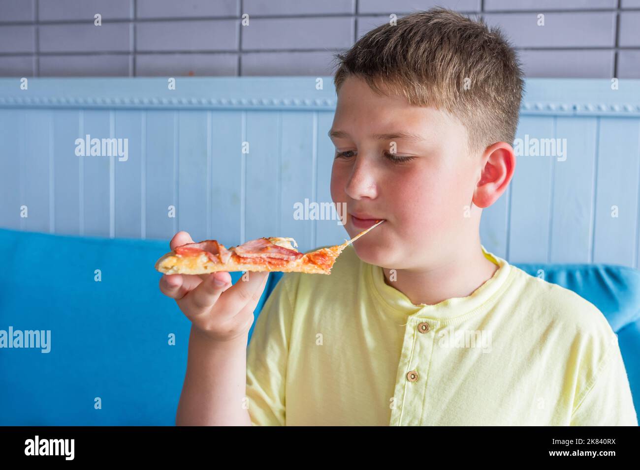 A boy eats Italian pizza in a cafe. Close-up Stock Photo