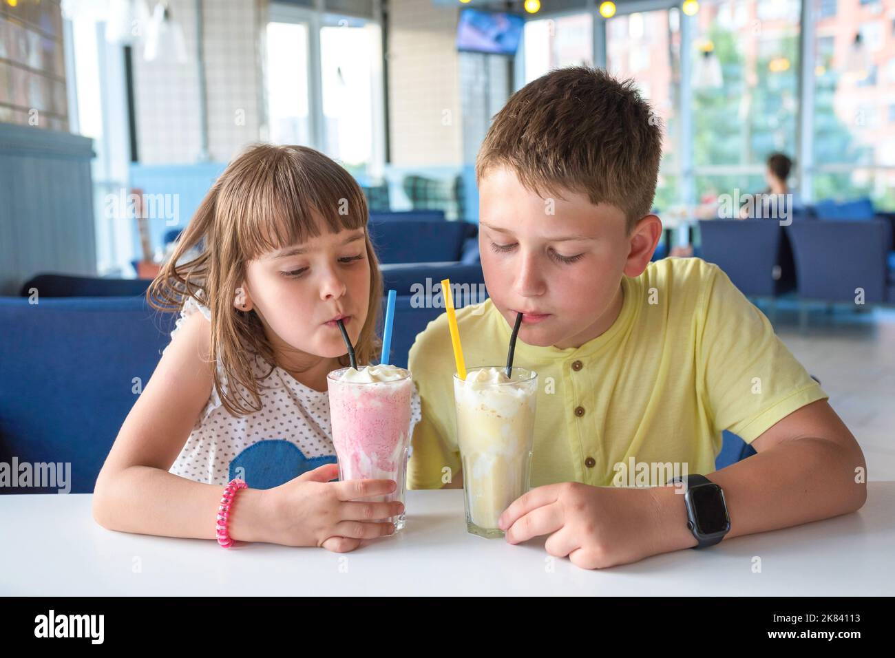 Happy children drink milkshakes in a cafe. Closeup Stock Photo Alamy
