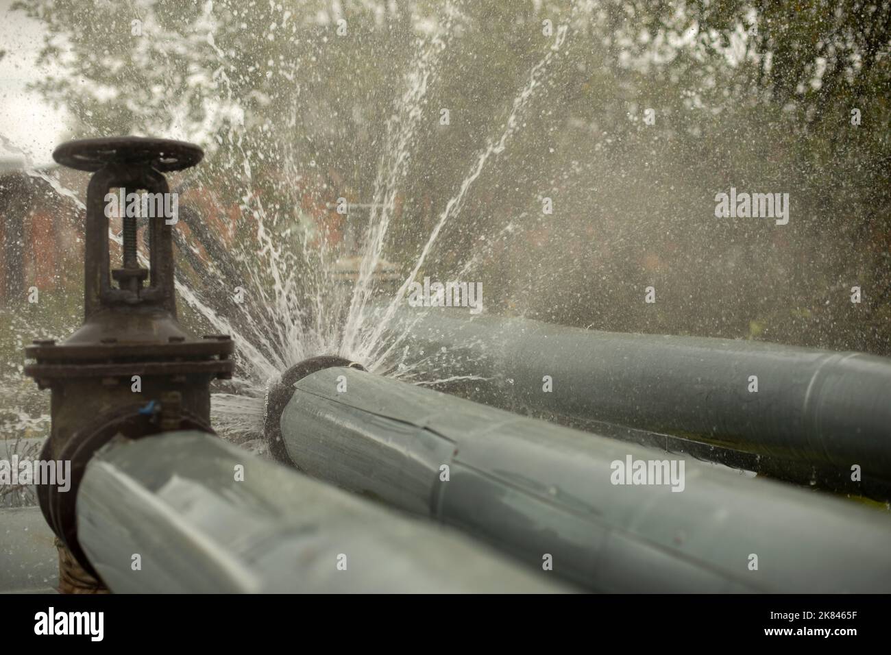 Breakthrough heating pipe. Pipeline accident. Boiling water pours out. Loss of tightness. Stock Photo