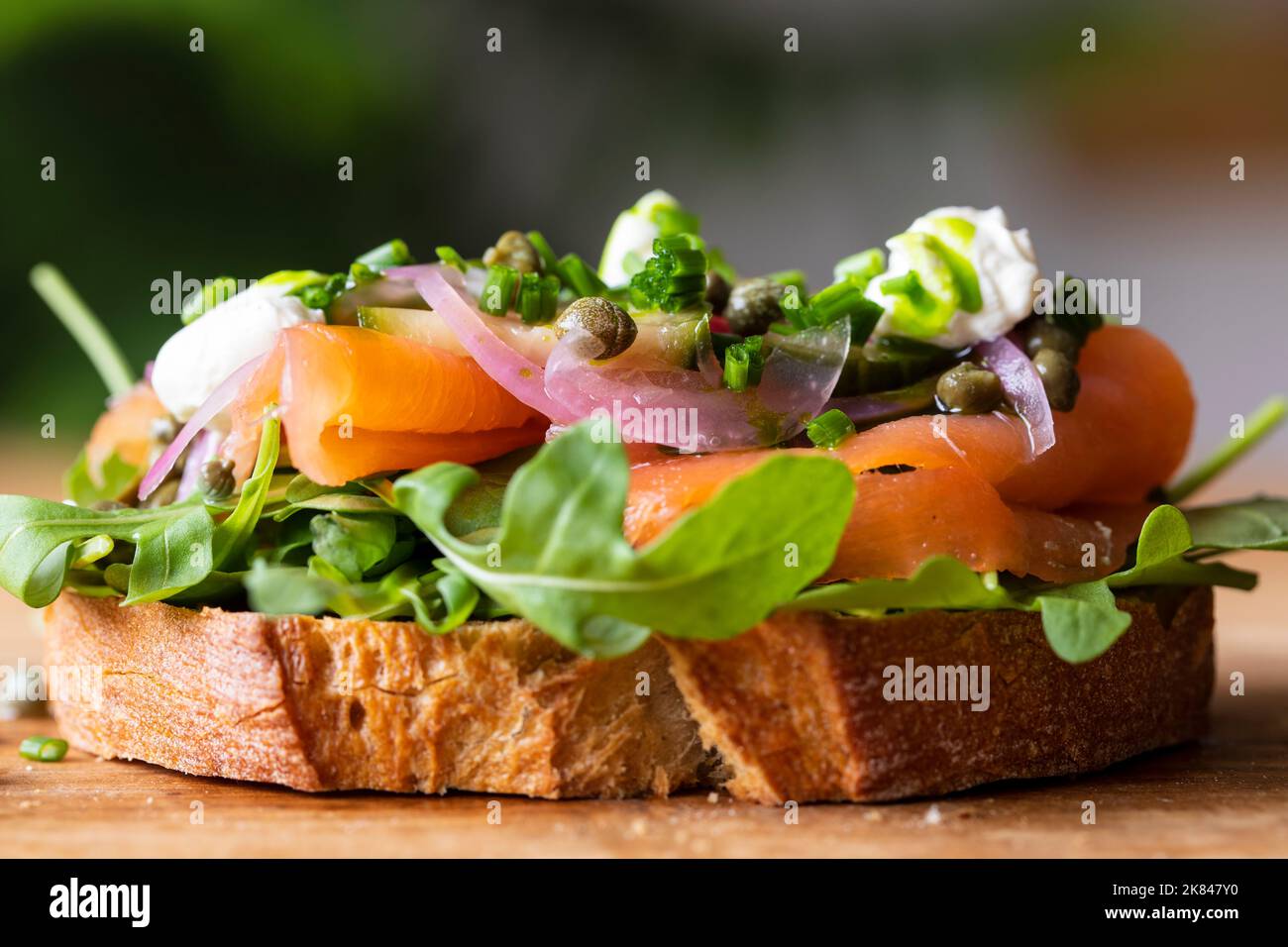 Open sandwich with smoked salmon, pickled onions, sour cream and capers Stock Photo