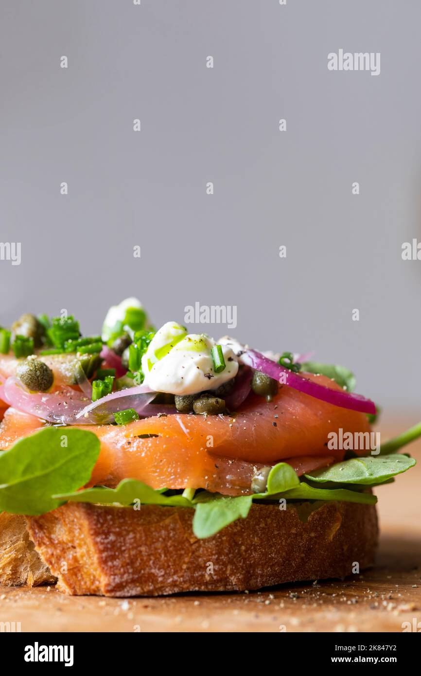 Open sandwich with smoked salmon, pickled onions, sour cream and capers Stock Photo
