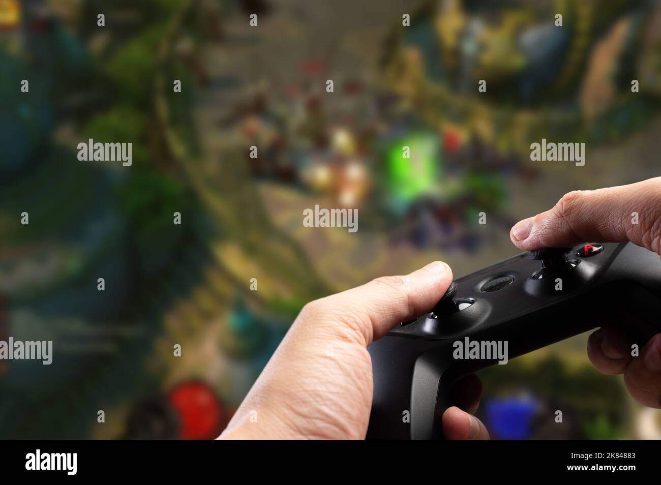 A modern GAM22ICB gamepad in the hands of a gamer against the background of a bright adventure
