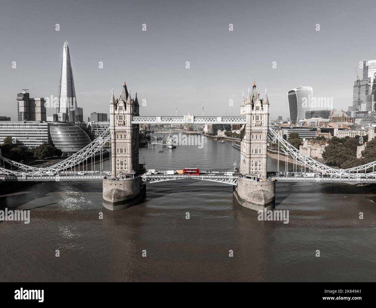 Beautiful black and white photo of London Tower bridge with an iconic red bus driving on it. Stock Photo
