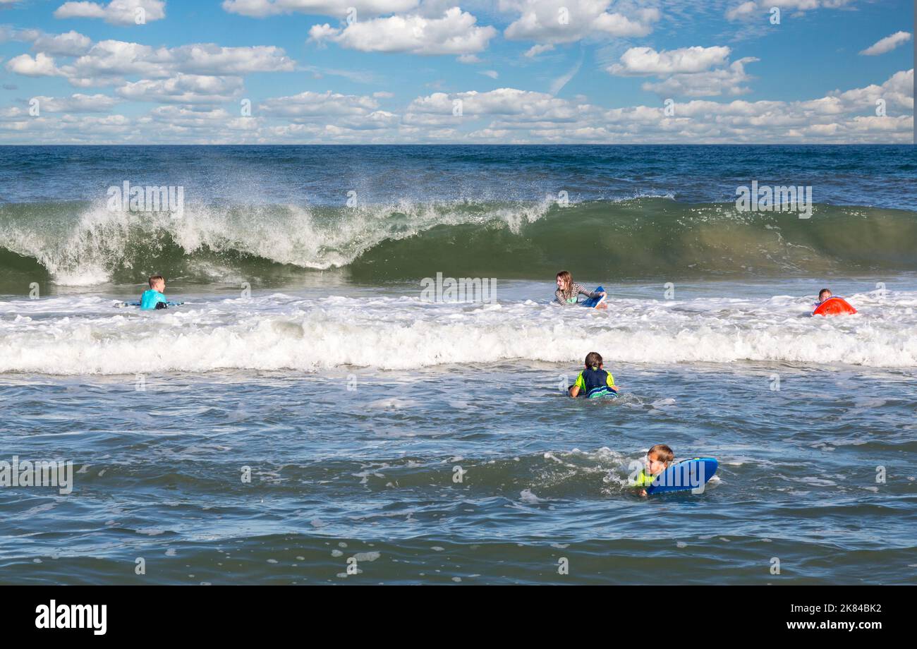 Avon, Outer Banks, North Carolina, USA.  Teenage and Pre-teenage Children in the Atlantic Surf with their Boogie Boards. Stock Photo