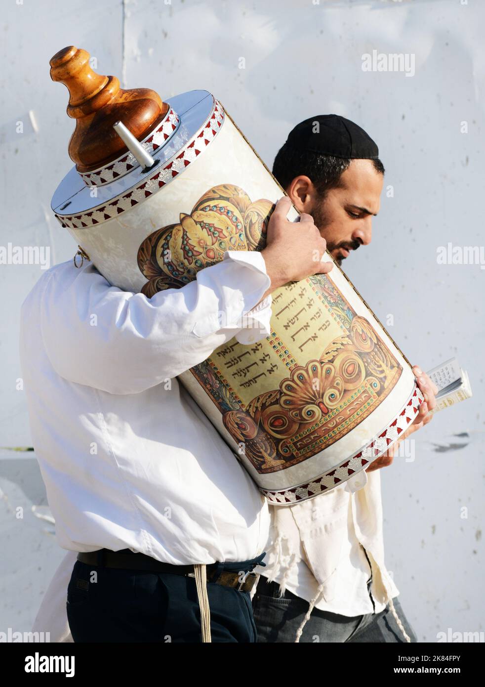 An Orthodox Jewish man holding the Torah scroll books at the Wailing wall in Jerusalem. Stock Photo