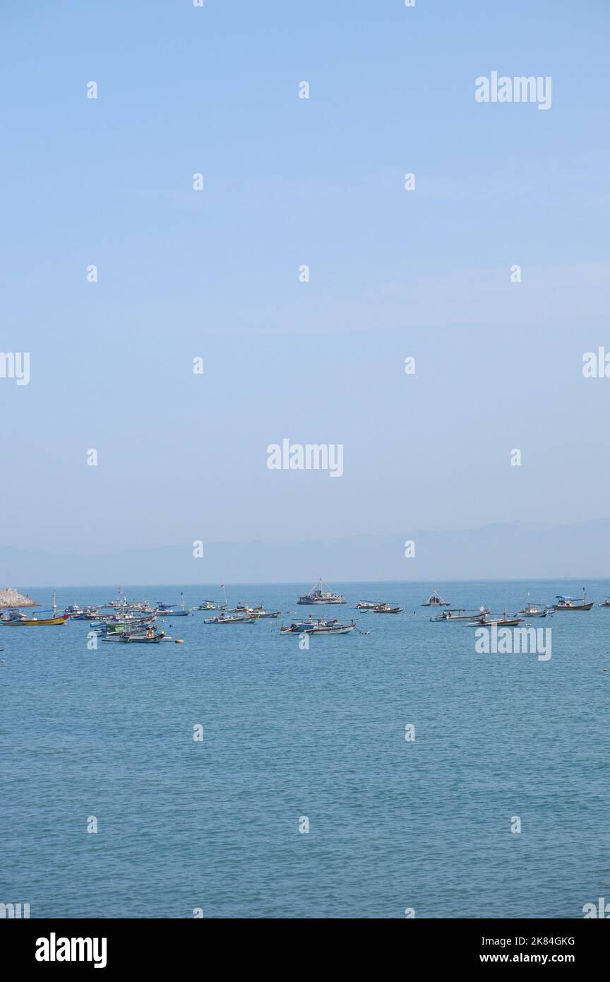 A group of fishing boats are preparing in the middle of the sea to catch fish,With mountain views and sunny weather, fishermen are excited Stock Photo