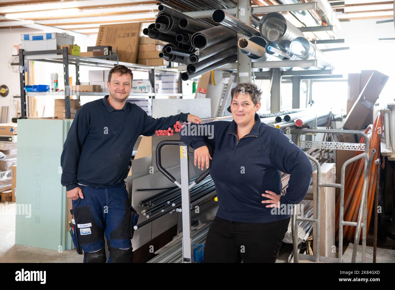 Denkingen, Germany. 11th Oct, 2022. Marcus Gaßner and his wife Ayleen  Bauser, owners of the company Gaßner Sanitär Heizung Fließen, look into the  photographer's camera in the warehouse. At the Gaßner company,