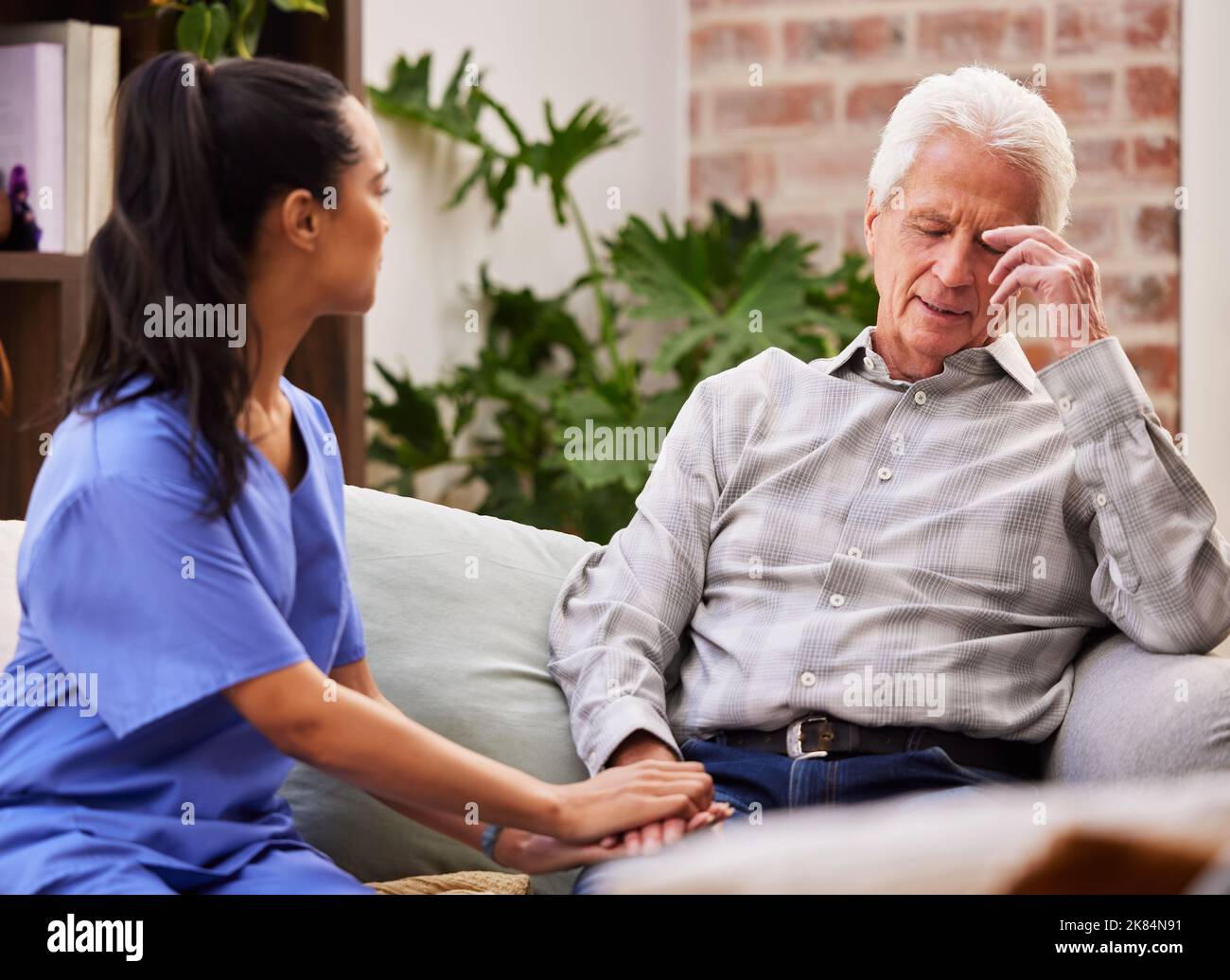 Its been such a heavy day. a young female nurse giving her elderly patient support. Stock Photo