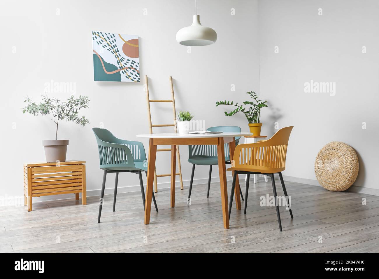 Stylish interior of dining room with modern furniture and houseplants ...