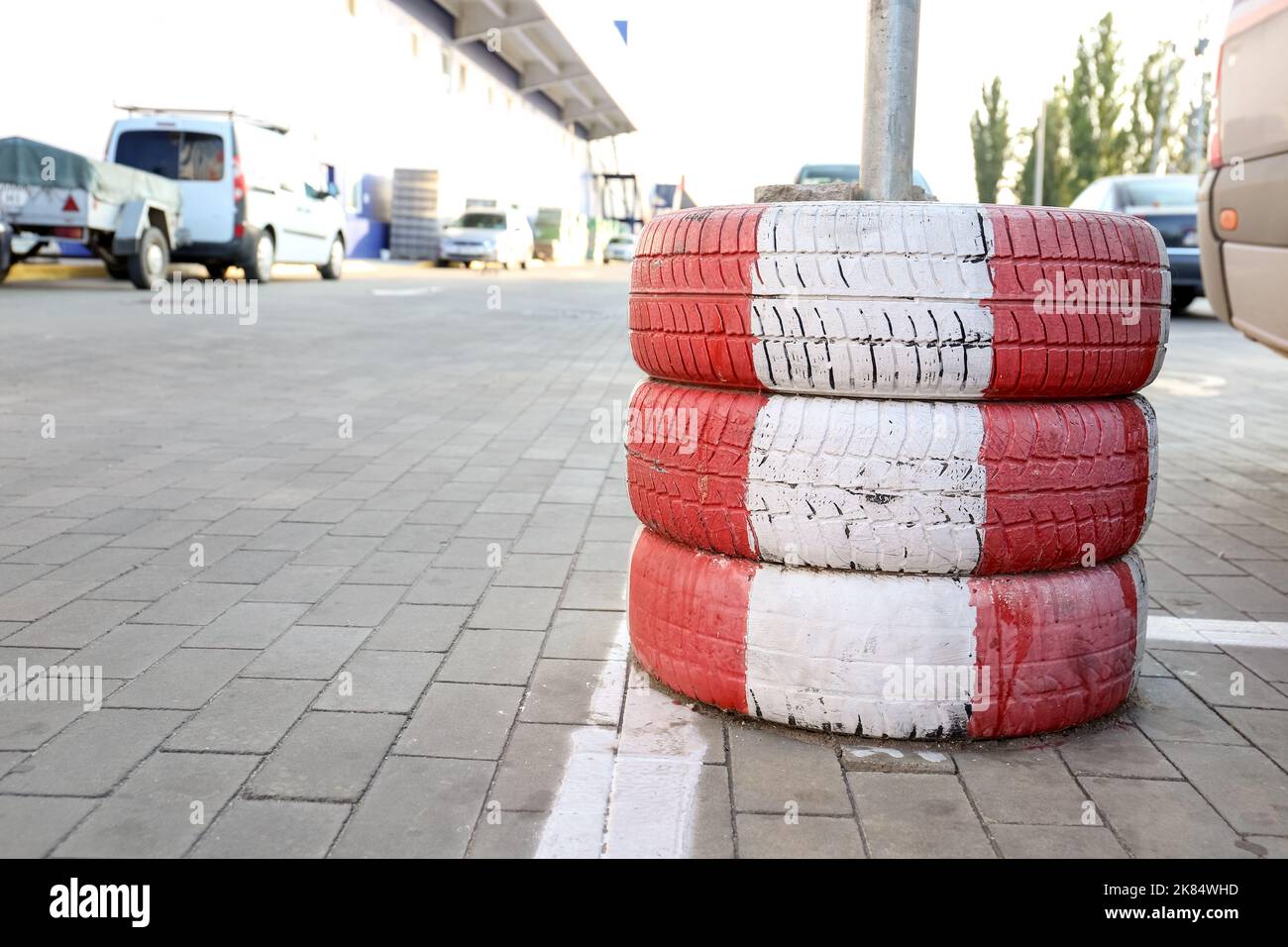 Limiter made of tires with red and white stripes on parking lot Stock