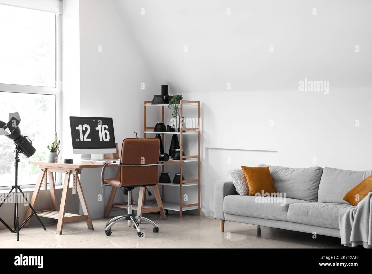 Interior of light office with photographer's workplace, shelving unit and equipment Stock Photo