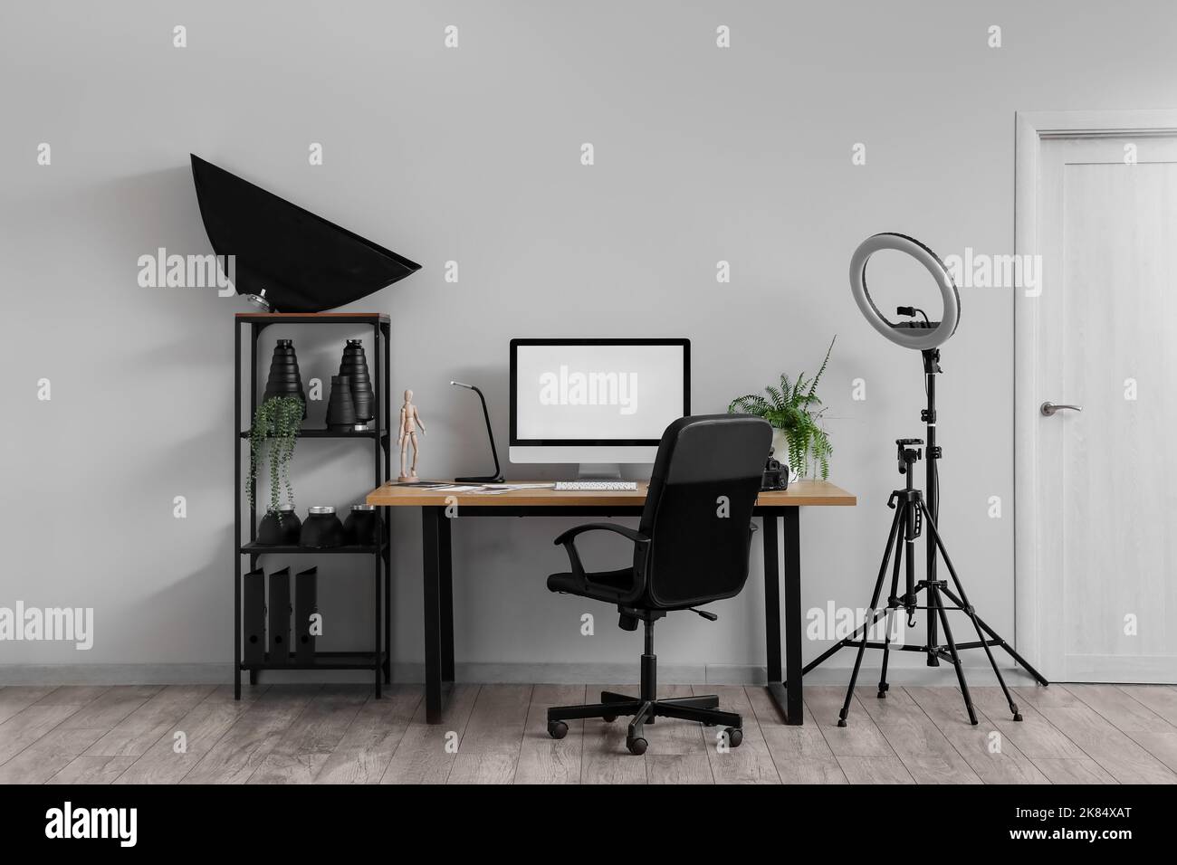 Interior of modern office with photographer's workplace, shelving unit