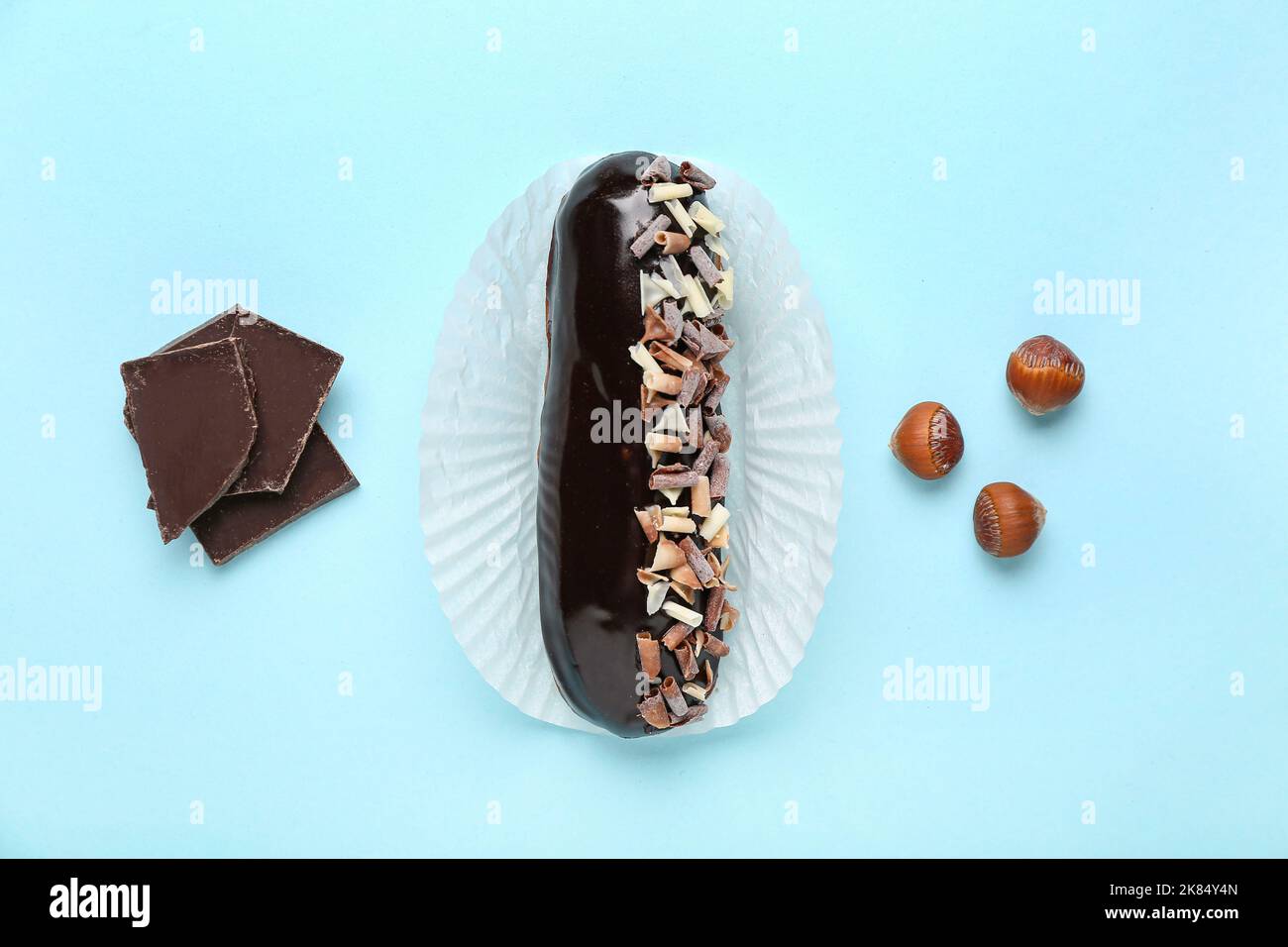 Tasty chocolate eclair on color background Stock Photo