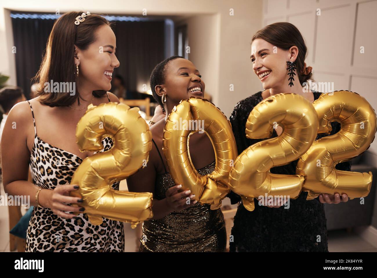 Were ready for the New Year. a diverse group of friends standing together and holding 2022 balloons during a New Years dinner party. Stock Photo