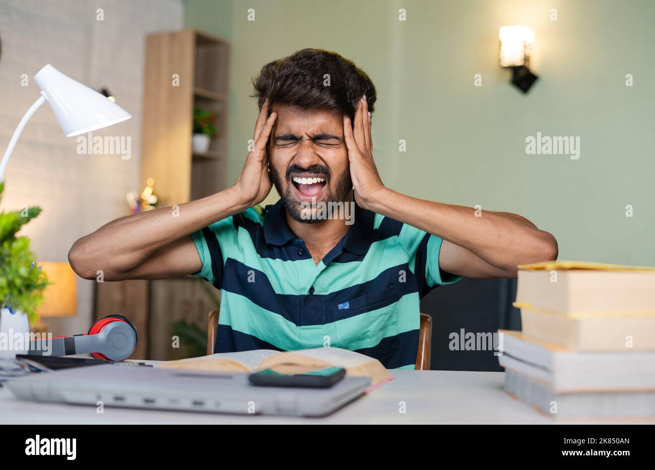 frustrated student while reading books before the examination - concept of difficult in understanding, exam tension and stress. Stock Photo