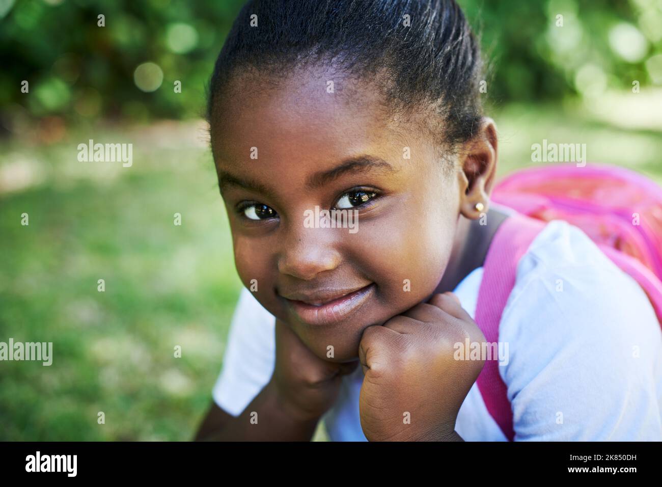 School rules. a little girl wearing a backpack while carrying books in
