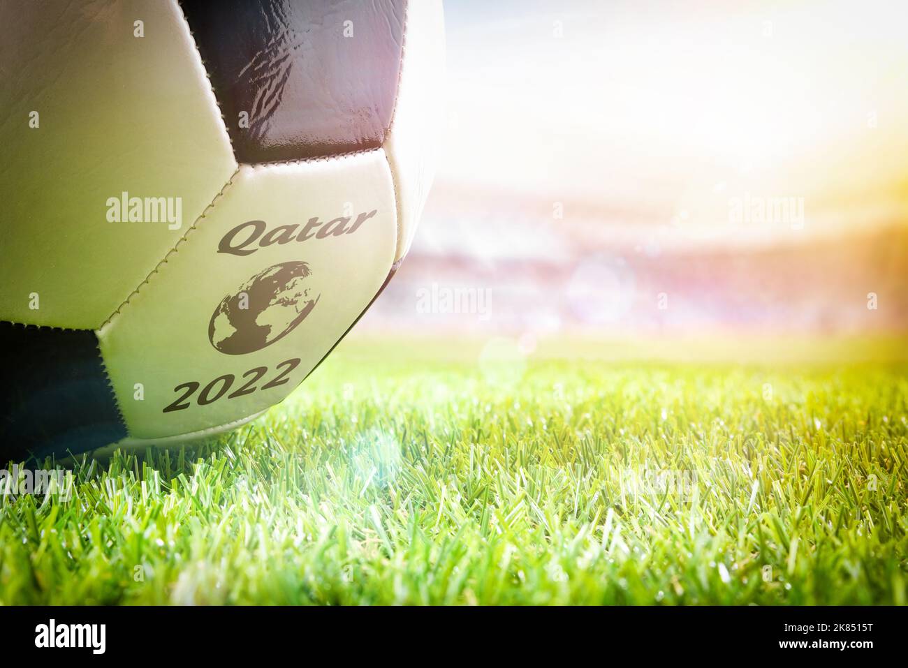 Detail of a ball on the grass of a soccer stadium announcing the world cup tournament in Qatar 2022. Stock Photo