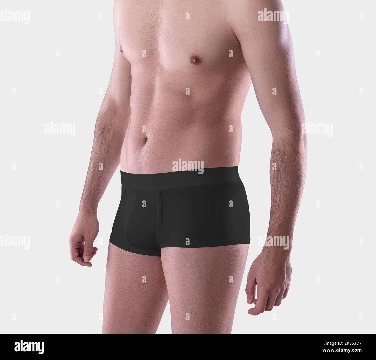 Template black cotton masculine boxers on a man, close-up, brief trunks isolated on the background in the studio. Mockup of male underpants, clothing Stock Photo