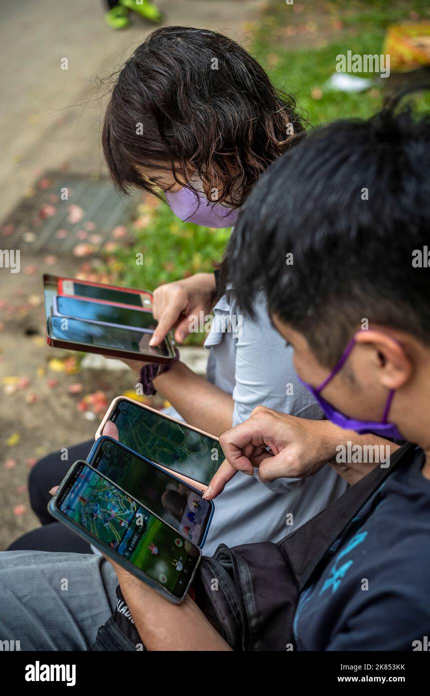 Taipei. 21st Oct, 2022. Gamers use several mobile phones as Pokemon hunters gathered at Daan Forest Park in Taipei, Taiwan during Pokémon GO Safari Zone on 21/10/2022 by Wiktor Dabkowski Credit: dpa/Alamy Live News Stock Photo