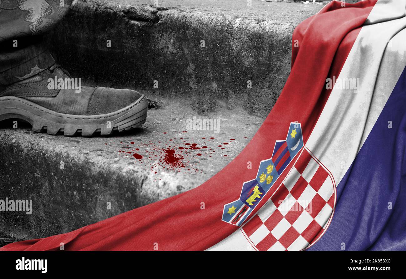 The leg of the military stands on the step next to the flag of Croatia, the concept of military conflict Stock Photo