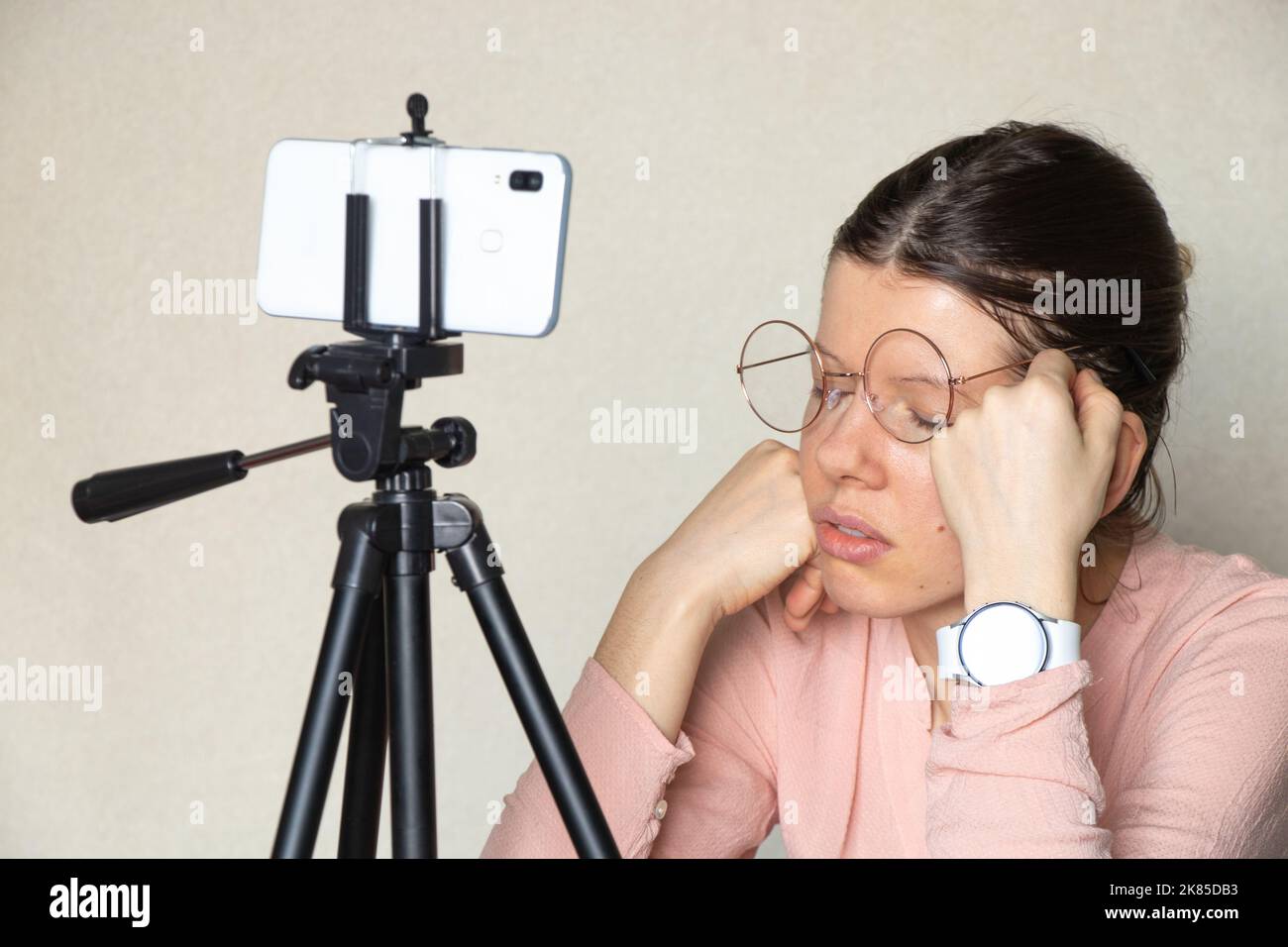 online education, the girl sleeps while watching a video lesson on the phone, online conference, sleep and overwork Stock Photo