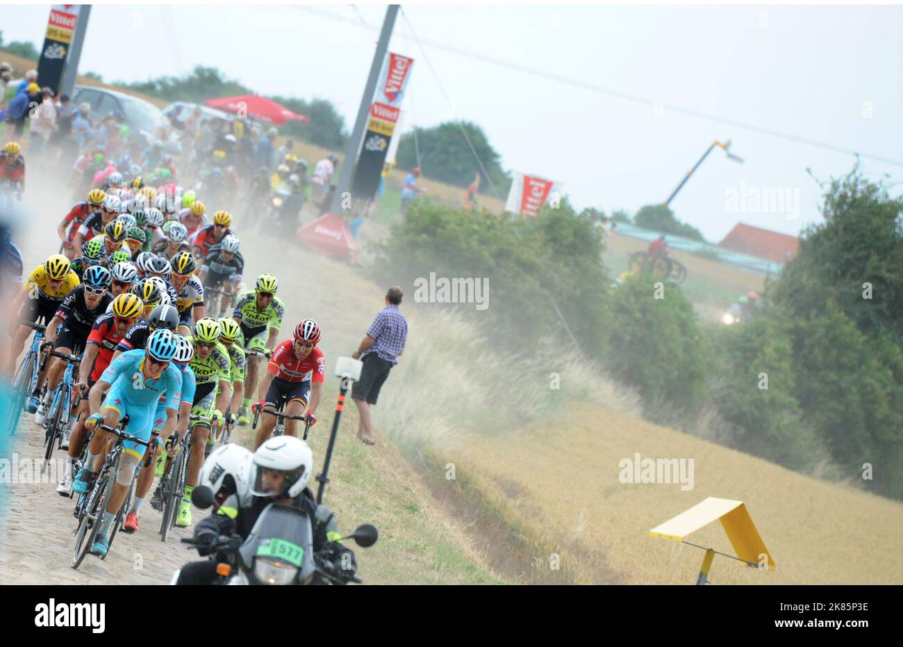 Geraint Thomas and Chris Froome in the yellow jersey sit tight in the cloud of dust kicked up by the main bunch riding over the cobbles of Saint Python Stock Photo