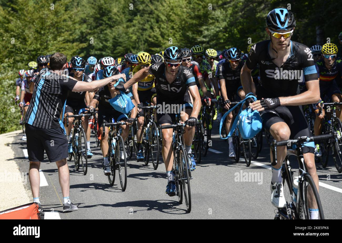 A soigneur hands out energy gels and water bottles on the way up the