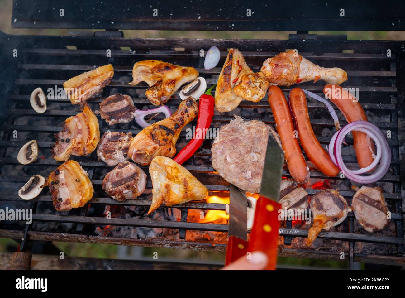 Assorted meat from chicken and pork and various vegetables on barbecue