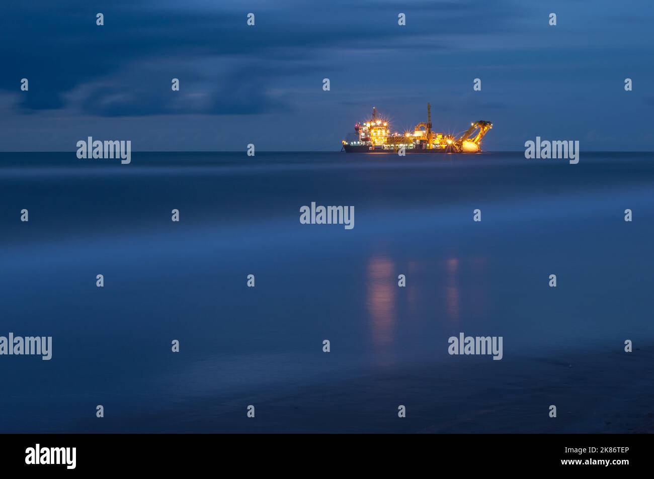 Night shot of a ship laying a submarine cable Stock Photo