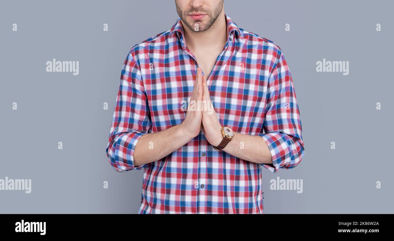 Religious man crop view pressing palms together, praying. Guy in casual