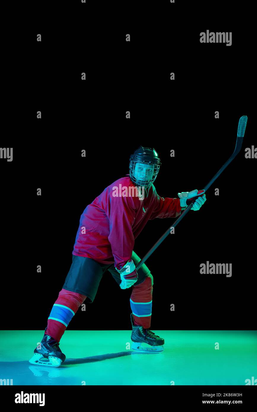 Powerful throw. Male ice hockey player in sports protective uniform in