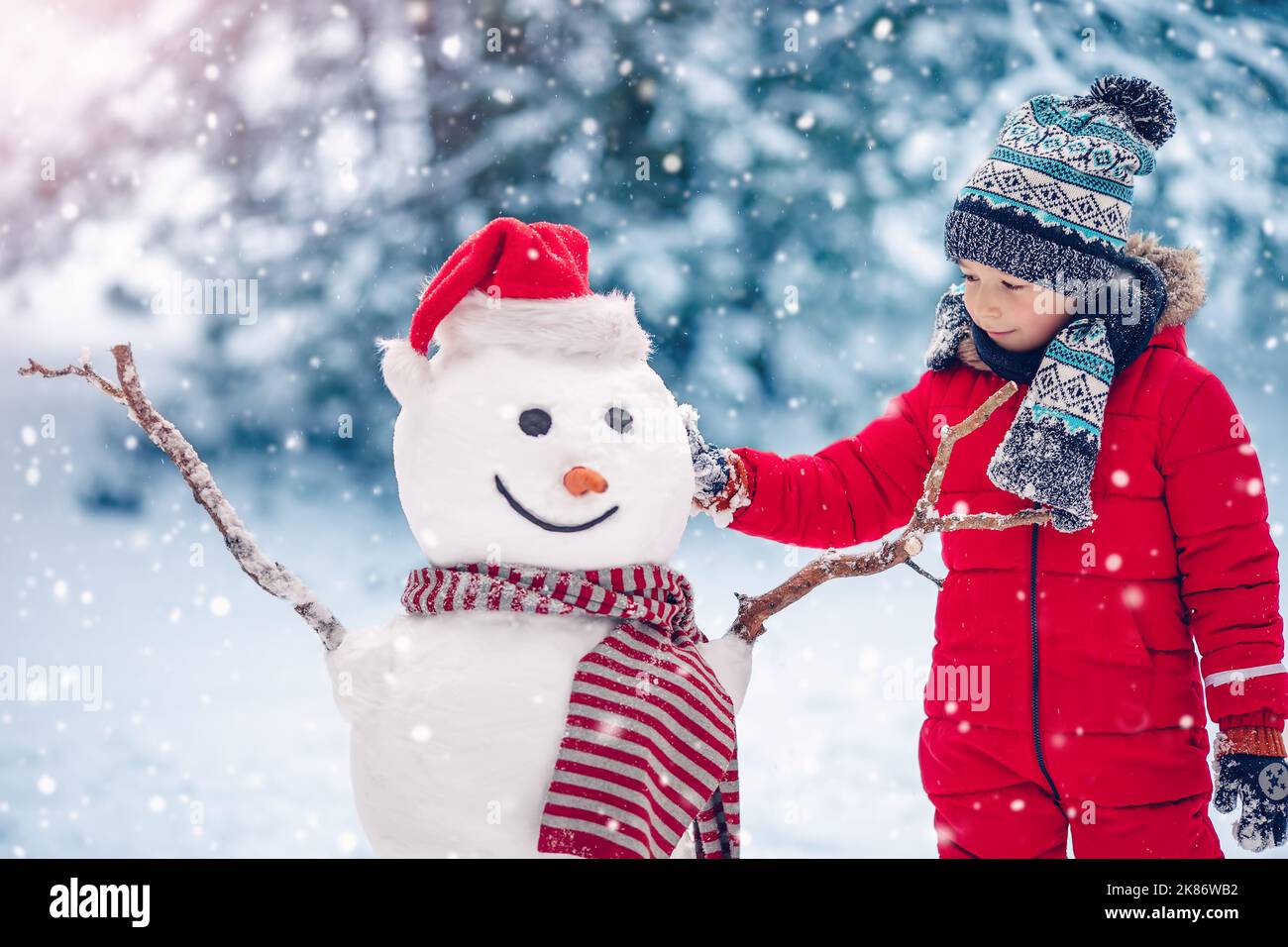 https://c8.alamy.com/comp/2K86WB2/small-smiling-child-building-a-cute-snowman-2K86WB2.jpg