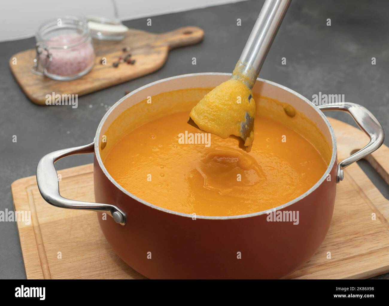 cooking pumpkin cream soup using an electric blender Stock Photo