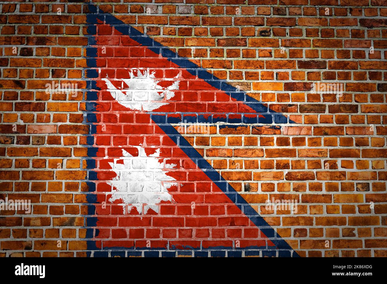 An image of the Nepal flag painted on a brick wall in an urban location ...
