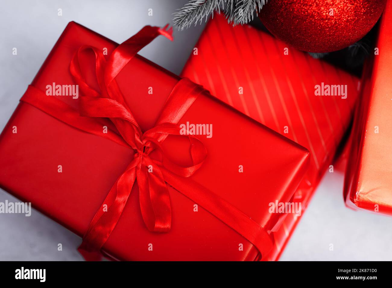Red gift boxes with ribbons and Christmas baubles on white background ...