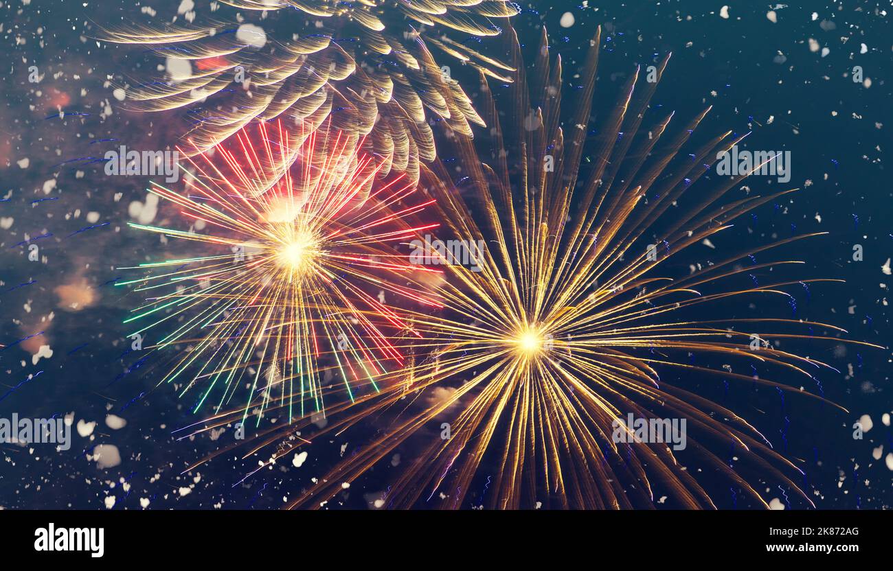 Festive fireworks during New Year celebrating, salute on the night sky and heavy snowfall, winter Christmas background Stock Photo