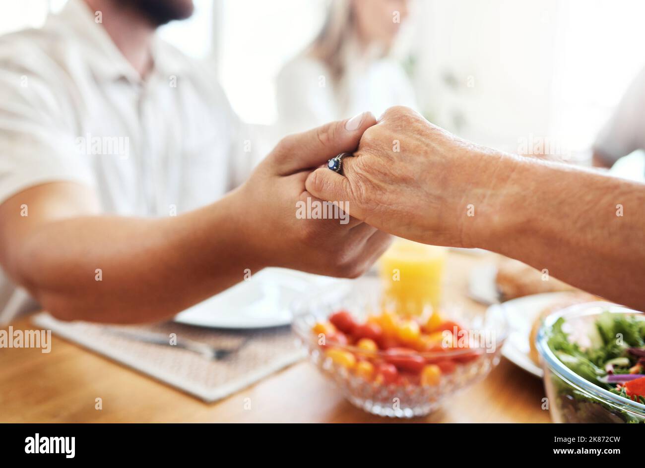 Family, hands and thanksgiving lunch prayer in house, home and restaurant with men, women and food. Zoom, worship praying community with hand, parents Stock Photo